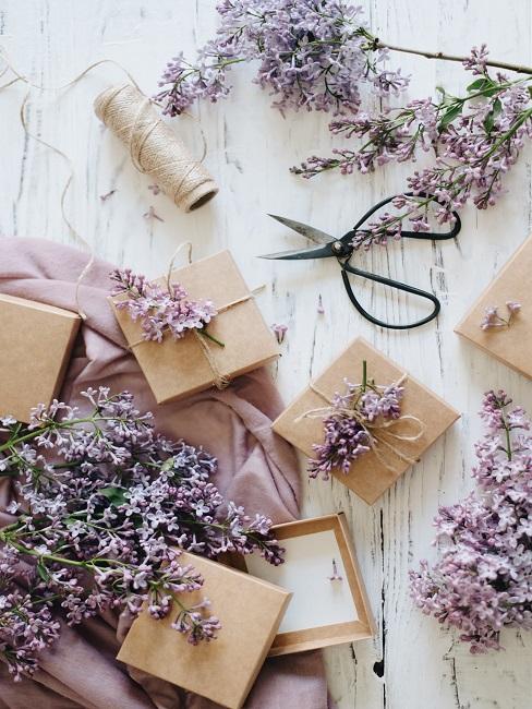 Geschenkboxen auf hellem Tisch mit Lavendel und einer Schere