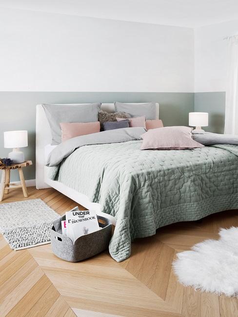 Zweifarbige Wand in Weiß und Pastellgrün in Schlafzimmer mit pastellgrüner Bettwäsche, rosa Kissen und weißem Lammfell am Boden