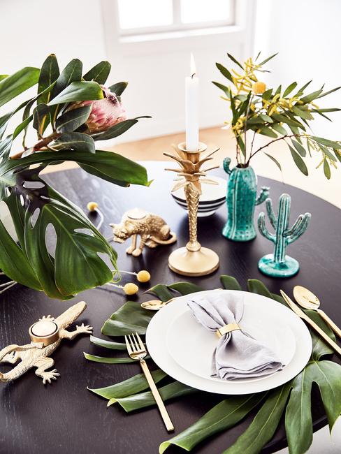 Mesa de comedor en negro con accesorios tripicales, cactus azul y plantas