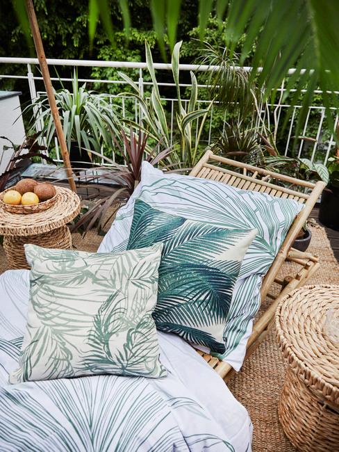 Terraza con hamaca de mimbre y motivos de palmeras estilo tropical