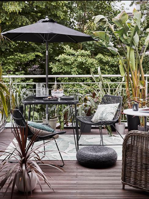Terraza con plantas y muebles de mimbre en tonos negros