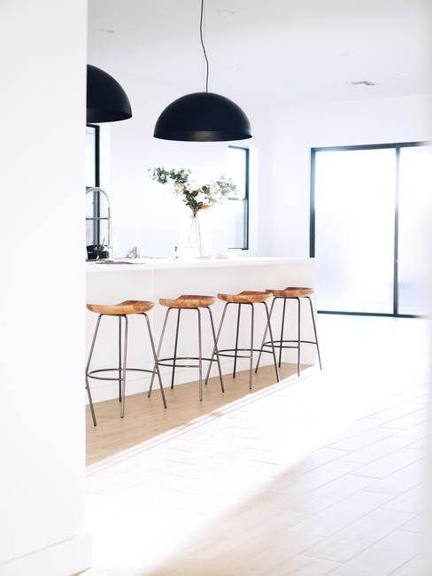 lampara-cocina-banner Lámparas de campana grandes en color negro encima de una cocina blanca con taburetes de madera blancos