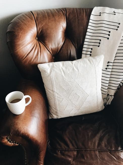 texturas-superficies-3d-banner Sillón de cuero marrón con manta y cojín así como una taza de café sobre el repozabrazos
