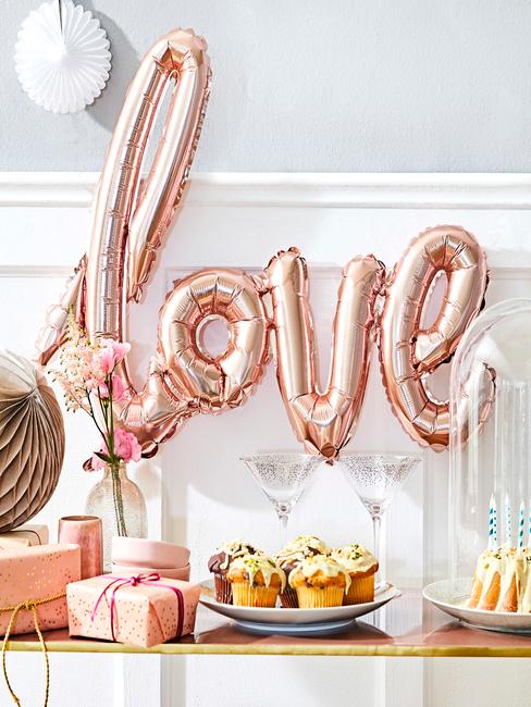 Balony Balon z napisem love wiszący nad zastawionym stołem