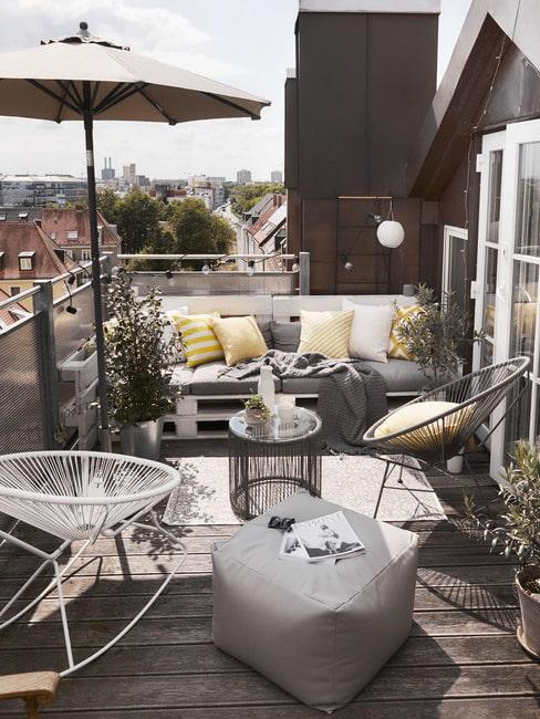 Balkon z drewnianą podłogą i meblami z palet