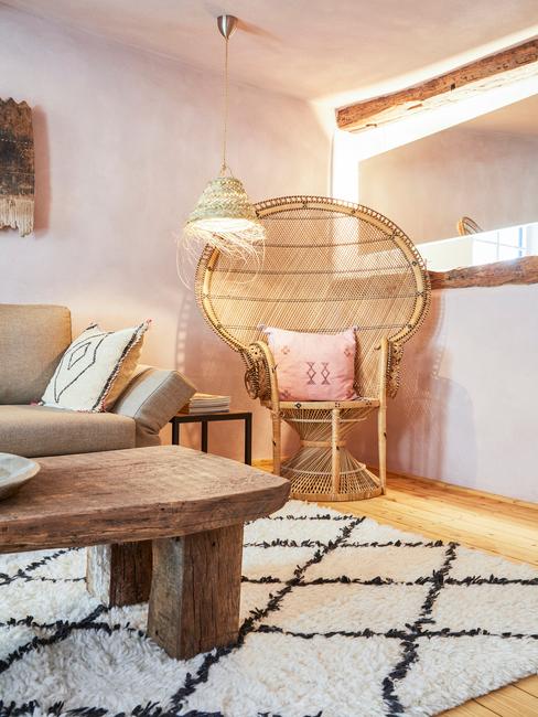 Jasny salon w stylu rustykalnym z drewnianym stolikiem kawowym, beżową kanapą oraz fotelem wykonanym z drewna bambusowego