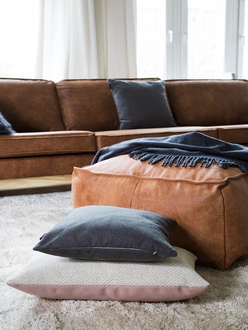 Großes braunes Ledersofa mit dunklen Kissen
