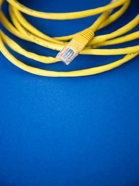 Kabel verstecken Gelbes gerolltes Kabel auf einem blauen Untergrund