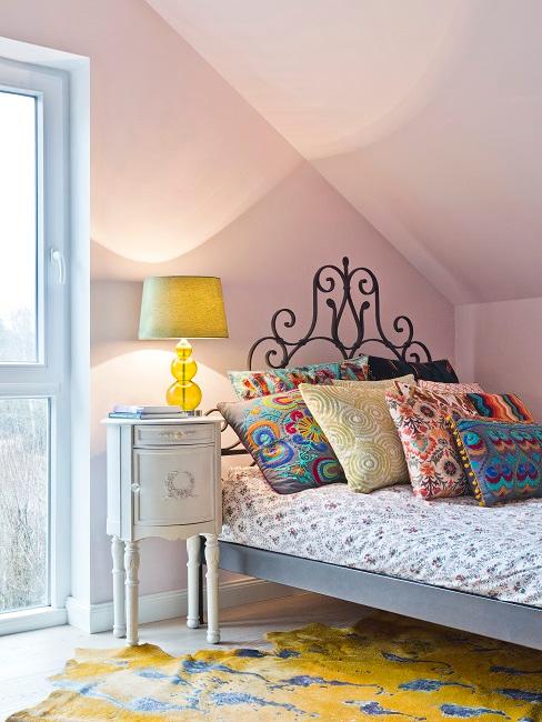Schlafzimmer mit verschnörkeltem Bettkopf und Wänden in Rosa