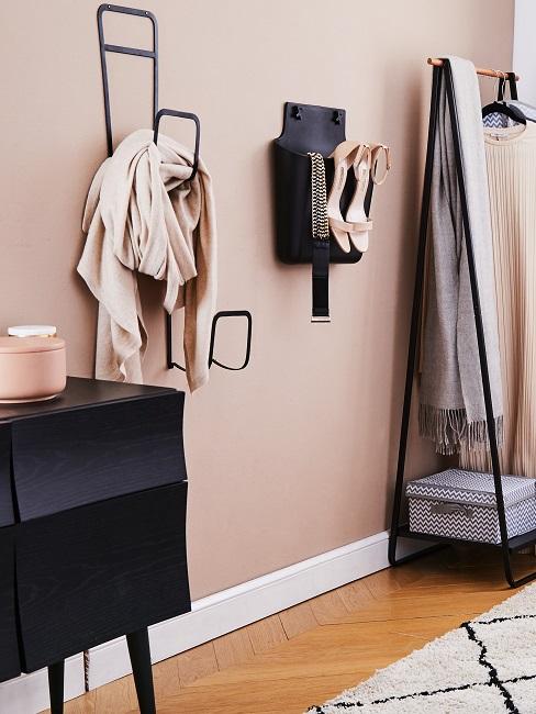 Schwarze Garderobe Elemente vor einer hellrosa Wand