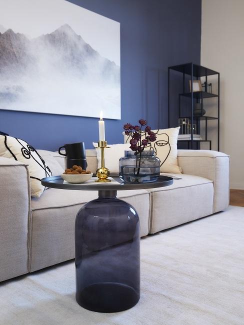 Blauw Header Blauwe wand met beige bank en tapijt met blauwe bijzettafel
