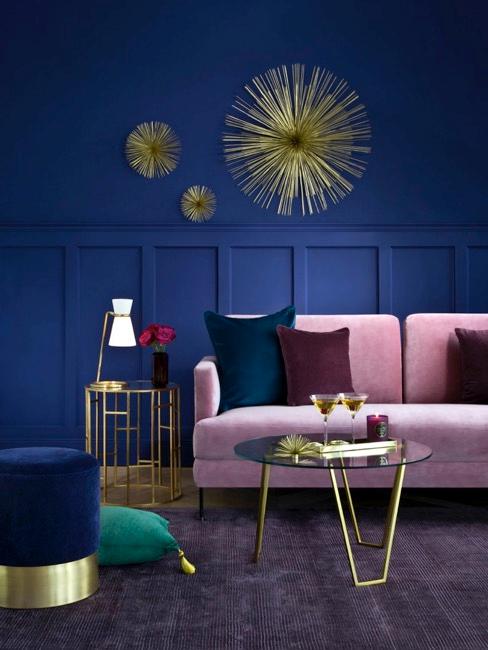 Blaues Wohnzimmer mit goldener Wanddeko in Metall