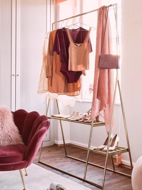 Gouden kledingrek met roze en rode kleding