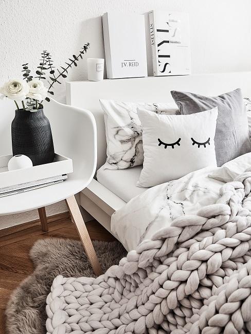Familienbett Bett mit kuscheliger Strickdecke, Kissen, Deko auf dem Bettkopf und dem Stuhl daneben