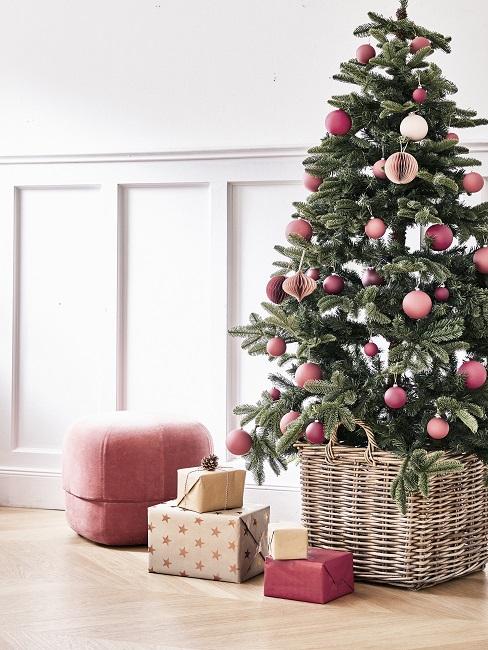 Weihnachtsbaum schmücken Weihnachtsbaum vor einer Wand, daneben ein Pouf und Geschenke