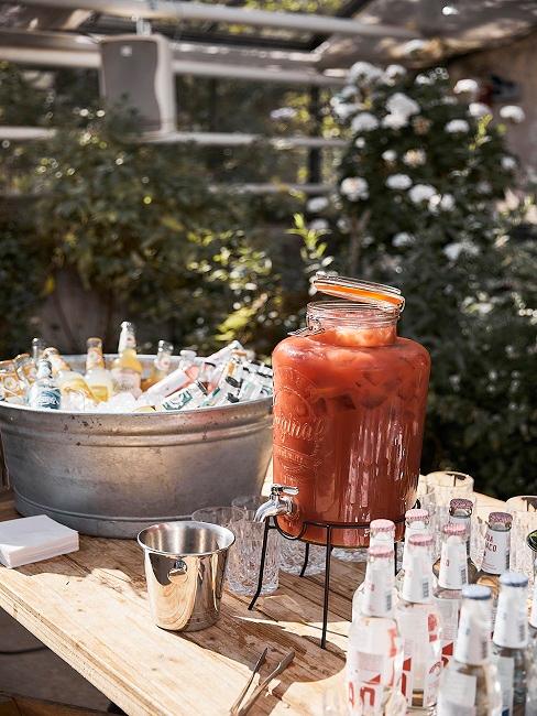 Getränkespender aus Glas mit Tomatensaft auf einer Anrichte