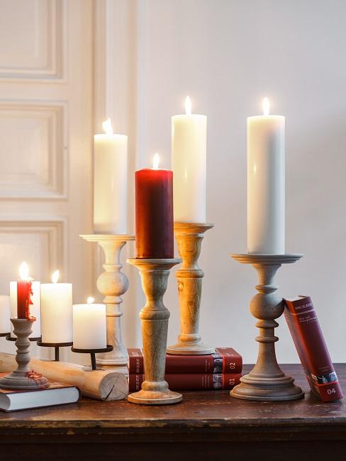 Kerzen selbst gestalten Viele brennende Kerzen in Kerzenständern auf einer Ablage