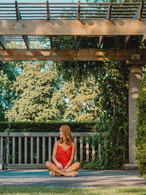 Pergola Pavillon Frau unter einem Pergola Pavillon im Garten sitzend