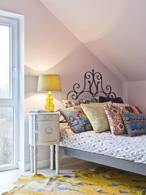 Schlafzimmer Farben: Rosa Wände, gelber Teppich, gelbe Lampe und Bett mit bunten Kissen