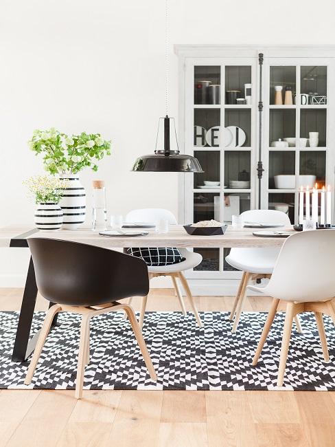 Helle Tischtafel auf schwarz-weißem Muster-Teppich