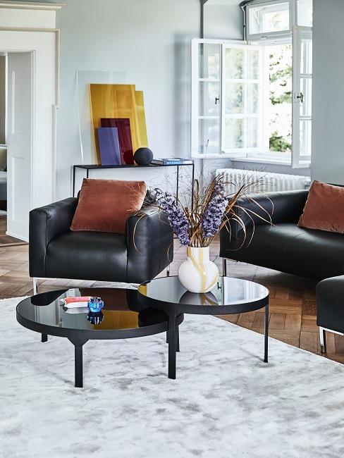 Richtig lüften Wohnzimmer Richtig lüften Wohnzimmer mit schwarzen Ledersesseln, braunen Kissen und schwarzem Couchtisch