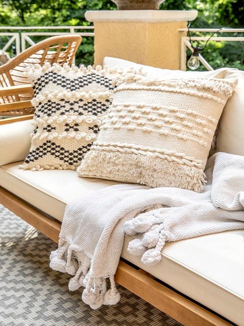 Helle, natürliche Dekokissen und Decke auf Loungemöbel im Garten