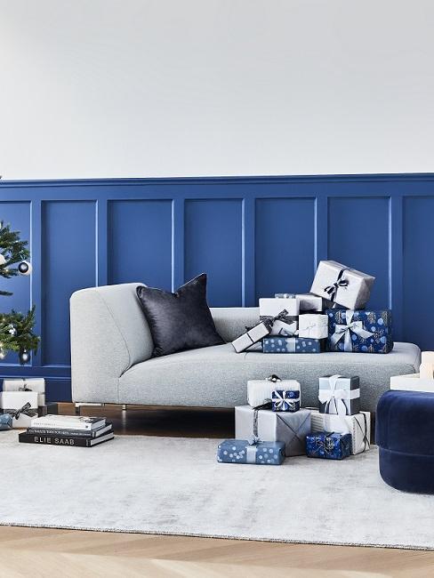 Blaue Wandvertäfelung mit grauer Couch und dunkelblauen Accessoires