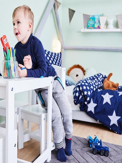 Kind im Kinderzimmer am Maltisch