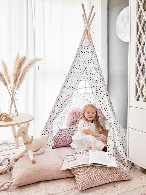 Kinder beschäftigen Kleines Mädchen sitzt in Tipi