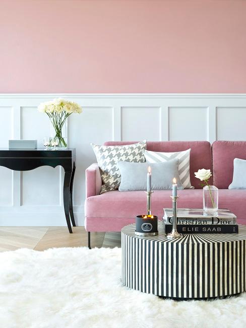 Wohnzimmer mit Altrosa Wandfarbe, rosa Sofa, schwarz-weißer Couchtisch, flauschiger Teppich in Weiß