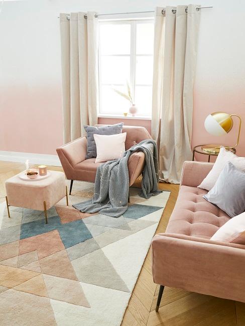 Wohnzimmer mit Altrosa Wandfarbe, rosa Sessel und Sofa, Teppich, Kissen und Decke in Weiß und Grau