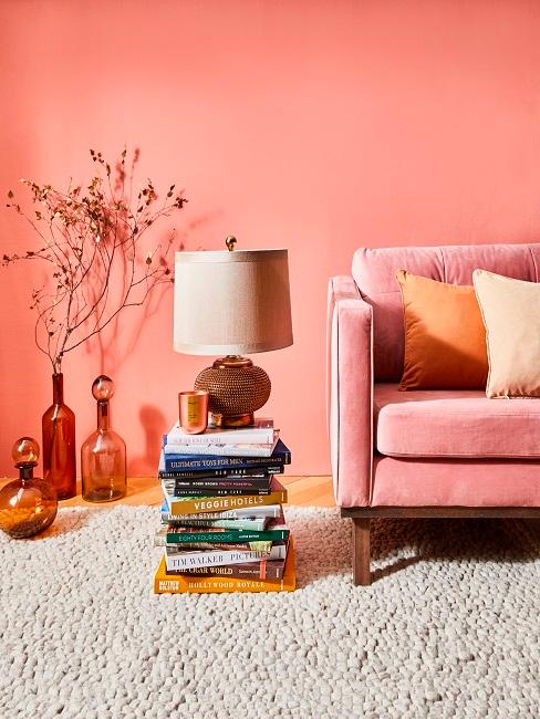 Wandfarbe Altrosa hinter rosa Sofa mit orangenen Kissen und orangenen Vasen