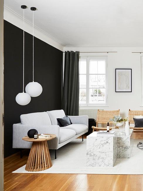 Wohnzimmer mit schwarzer Wandfarbe, weißem Sofa, Teppich und Leuchten, Marmortischen und Rattanstühlen