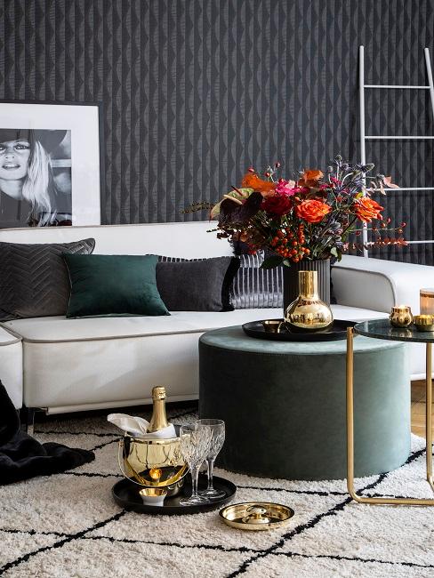 Schwarze Wandfarbe in Wohnzimmer mit grauem Sofa, grünem Samtpouf und Samtkissen in Schwarz und Grün