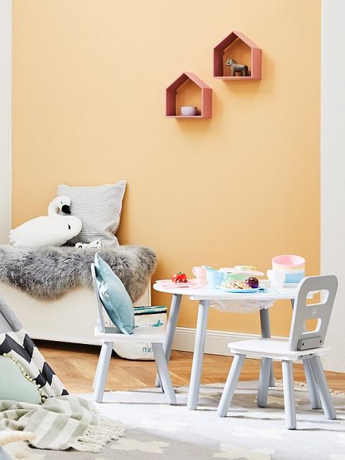 Apricotfarbene Wand im Babyzimmer mit weißen Möbeln und kuscheligen Textilien