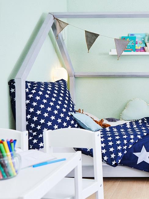 Grüne Wandfarbe im Babyzimmer mit Bett und blauer Bettwäsche