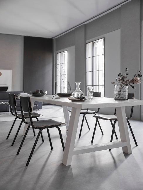 Graue Wände im Esszimmer mit weißem Esstisch und schwarze Stühle