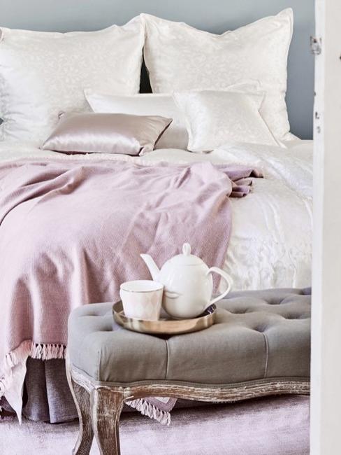 Gids slaapkamerbankje Vrouwelijke slaapkamer met bed en gedecoreerd slaapkamerbankje