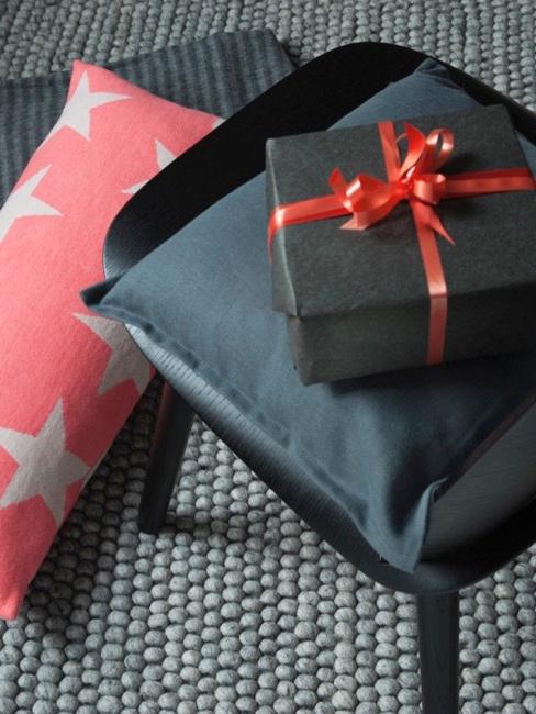 regalos para el día del padre regalo envuelto en papel negro sobre una silla negra y con un lazo decorativo