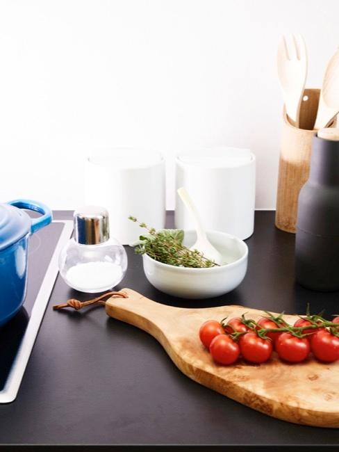 Tabla de cortar con tomates y accesorios de cocina