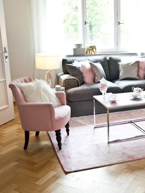 Szara sofa z różowymi poduszkami i różowym fotelem w salonie