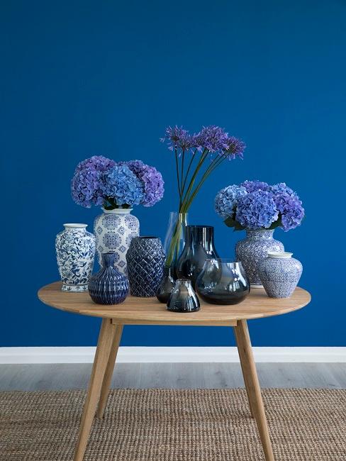 Blumendeko Tisch Kleiner Tisch aus Holz mit sehr vielen Vasen und Blumen in Blautönen