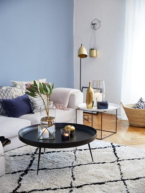 Gedeckte Farben Wohnzimmer Gedeckte Farben im Wohnzimmer mit blauer Wand, hellem Sofa, schwarzem Tisch und kariertem Teppich