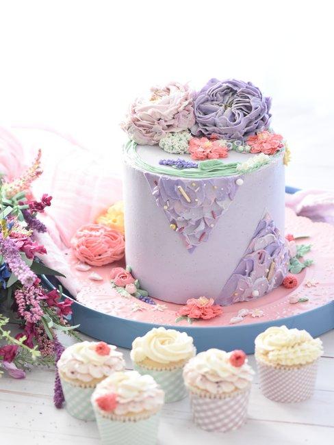 Babyshower spelletjes paarse taart Paarse taart met witte cupcakes op roze schaal