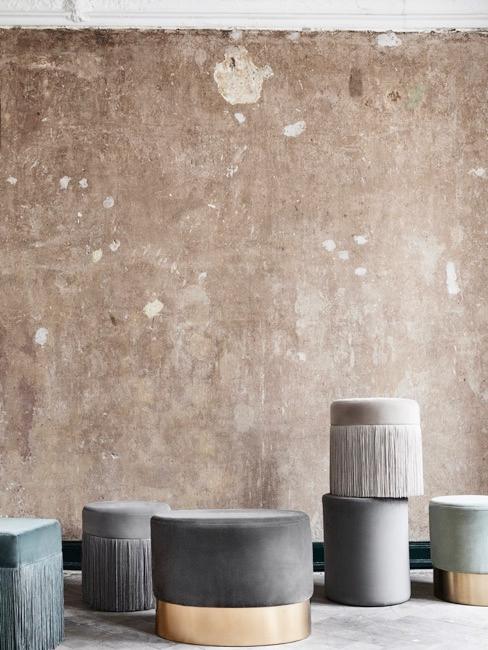 Poufs Pièce à murs gris bruts avec poufs de différentes tailles et couleurs