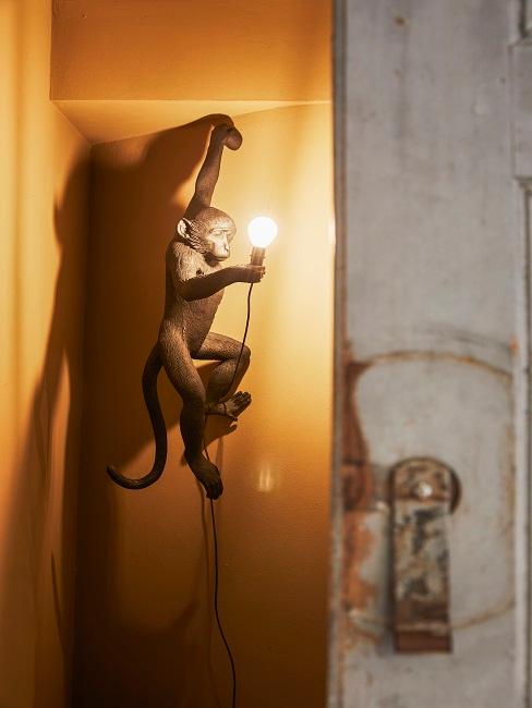 Affenlampe in Schwarz an der Wand hängend