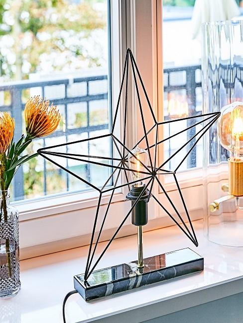 Deko-Leuchte in Stern-Form auf dem Fensterbrett in der Küche