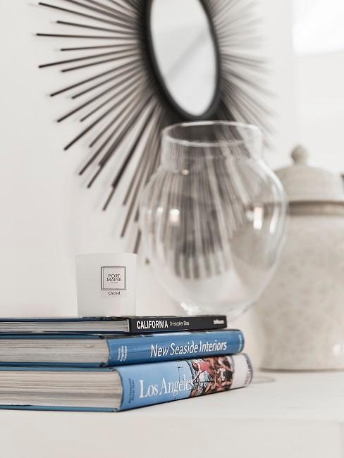 Bücherstapel vor großer Vase ohne Blumen