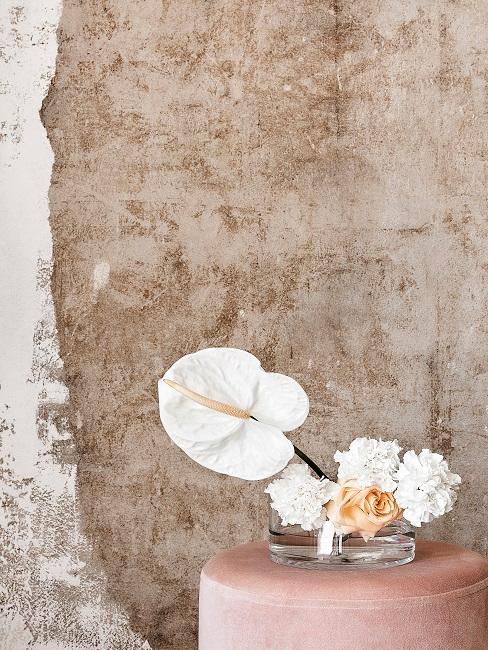 Helle blumen in tiefer Vase auf rosa Pouf