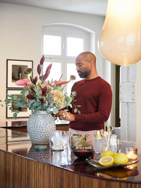 Mann am Blumen gestalten in großer Vase